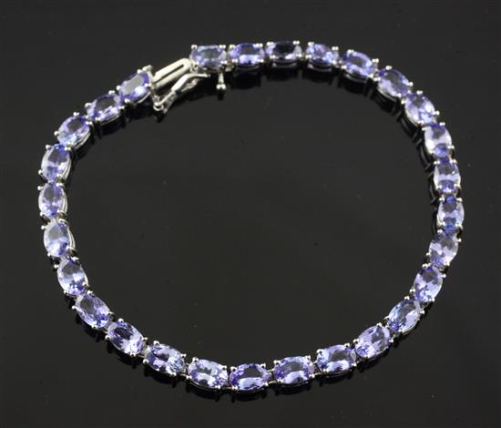 A 14ct white gold and tanzanite line bracelet by Kallati, 7.25in.